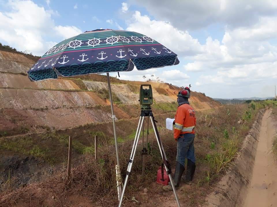 Equipe técnica realizando levantamento em corte de solo de obra industrial